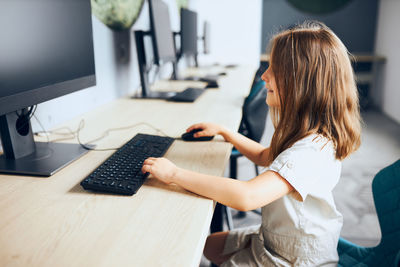 Midsection of woman using laptop on table