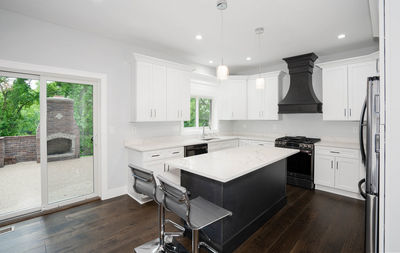 Remodeled kitchen has white cabinets installed and modern appliances