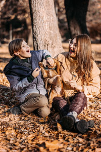 Autumn walks with dog. happy family mother and teen boy son having fun with cute cocker spaniel