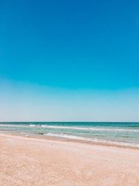 Scenic view of beach against blue sky