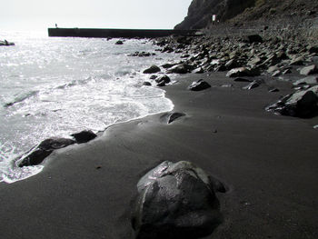 Rocks on beach against sky