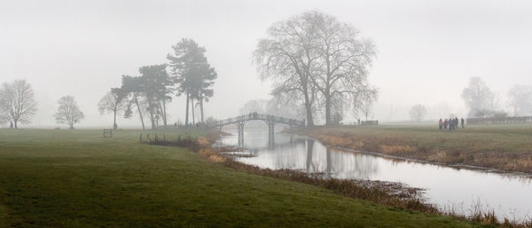 Scenic view of lake against sky during foggy weather