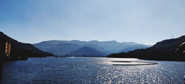 Scenic view of sea and mountains against clear sky