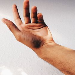 Close-up of hand against wall