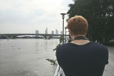 Rear view of man with city in background