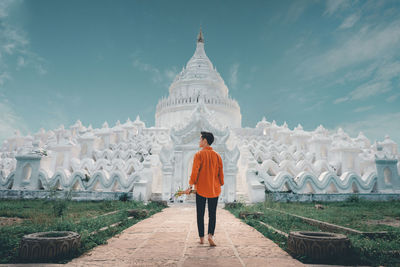Rear view of woman standing against temple
