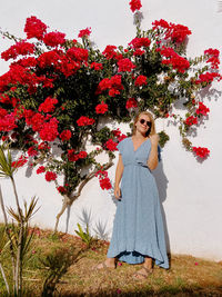 Portrait of woman with red flower against trees