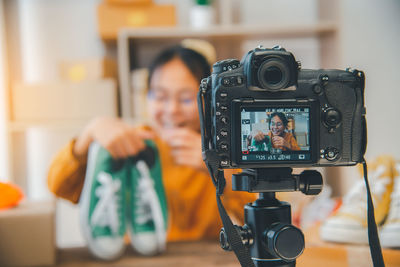 Girl blogging with shoes seen on screen of camera