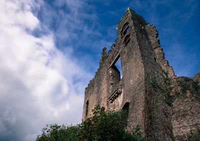 Low angle view of historical building against cloudy sky