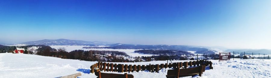 Panoramic view of snowcapped mountains against clear blue sky