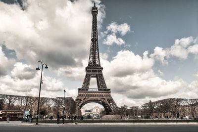 Tower in city against cloudy sky