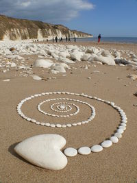 Text on sand at beach against sky