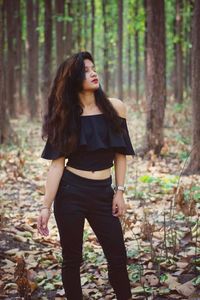 Full length of woman standing in forest