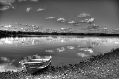 Boats moored on lake against sky