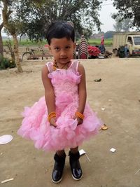 Portrait of cute girl standing on pink outdoors