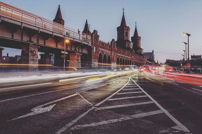 Light trails on road in city against sky