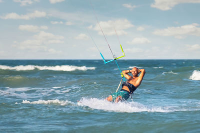 Man surfing in sea against sky