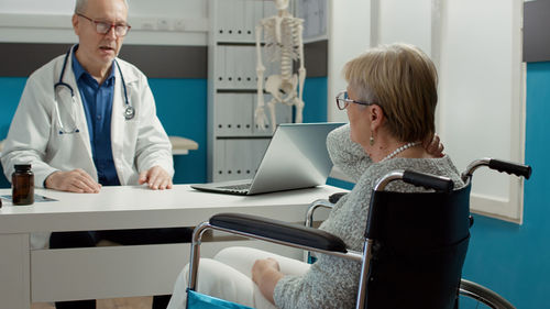 Side view of female doctor examining patient in medical clinic