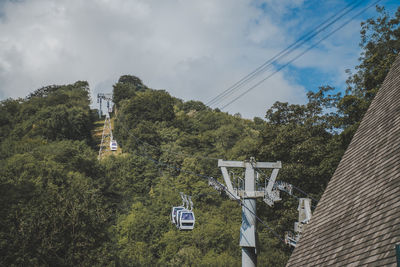 Low angle view of overhead cable car against sky