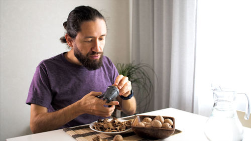 Man crushing walnut at home