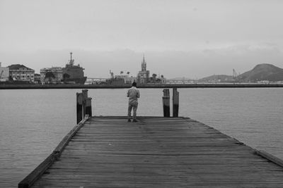 Rear view of man standing on pier