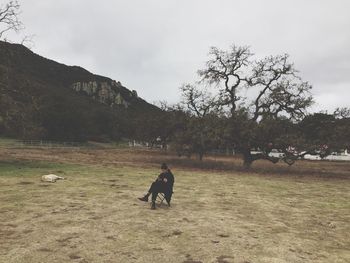 Man with dog on landscape against sky