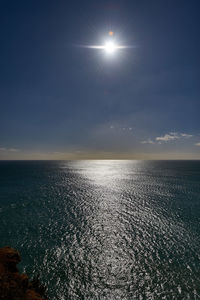 Scenic view of sea against bright sun