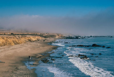 Scenic view of beach against blue sky