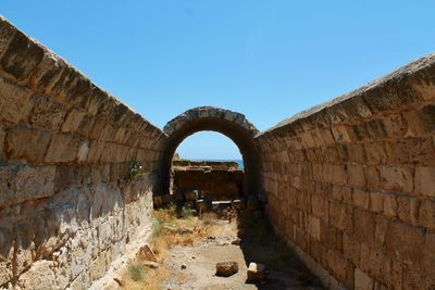 Archway of historical building against clear blue sky