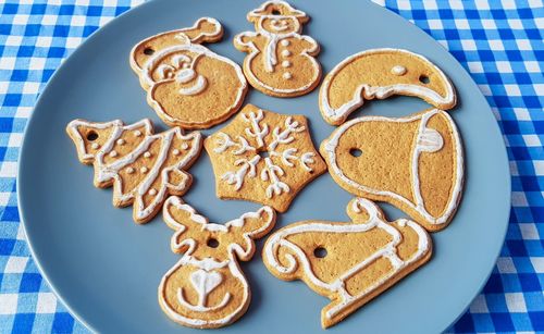 High angle view of gingerbread cookies in plate on tablecloth