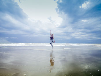 Person on sea shore against sky