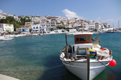 Sailboats moored on sea against buildings in city