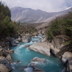 Scenic view of river and mountains against sky