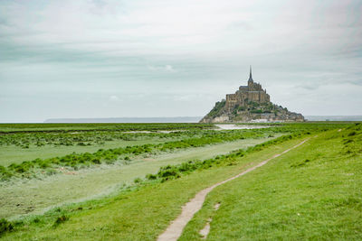 View of building on field against cloudy sky