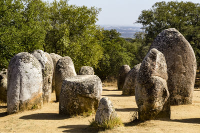 Stone sculpture on rock against sky