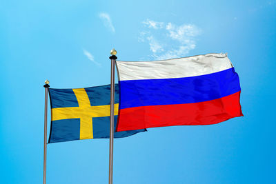 Low angle view of flag against blue sky
