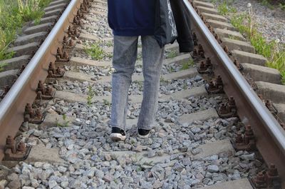 A man walking on rails, a view of feet walking on railroad tracks