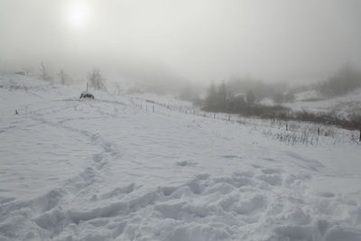 Scenic view of snow covered land against sky