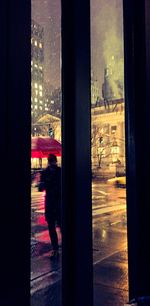 Side view of man looking through window