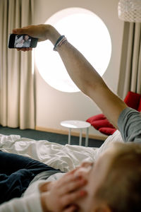 Father taking selfie with daughter on bed in hotel