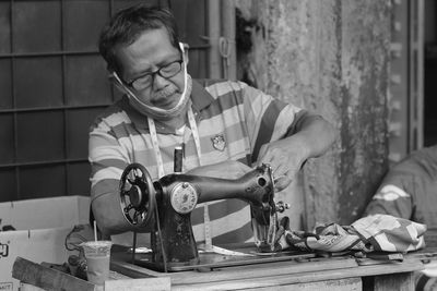 Portrait of man using sewing machine