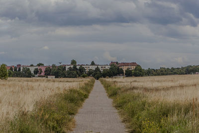 Scenic view of field against cloudy sky