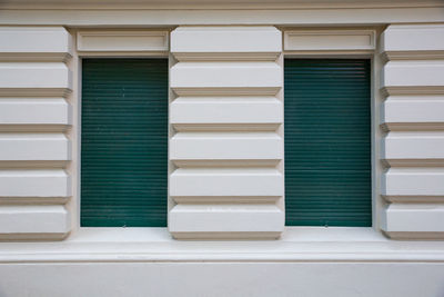 Closed green shutters of house windows