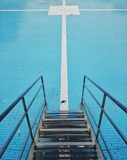 High angle view of steps leading towards blue cobbled street