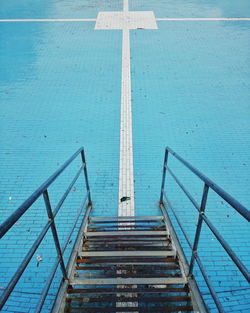 High angle view of steps leading towards blue cobbled street