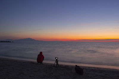 People on beach against sky during sunset