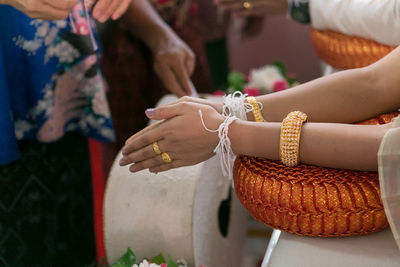 Cropped hands of bride praying in temple