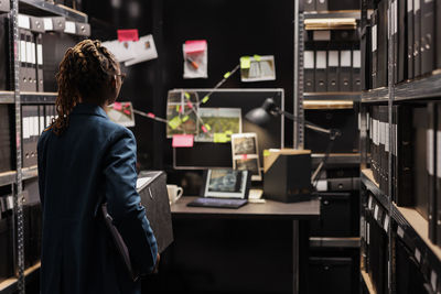 Rear view of woman standing in library