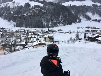 Man on snow covered field against mountain