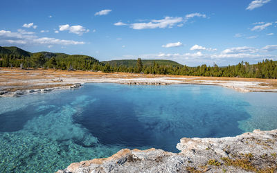 Scenic view of sapphire pool with sky in background at yellowstone national park